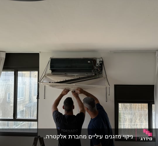 שני אנשים מתקנים מזגן תלוי על קיר